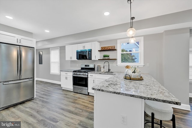 kitchen with light wood-type flooring, stainless steel appliances, plenty of natural light, and white cabinetry