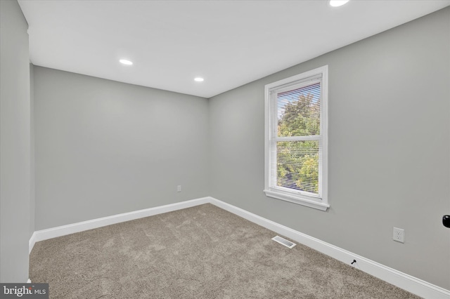 spare room featuring light colored carpet