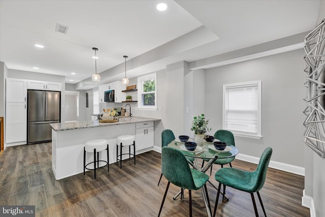 dining space with sink and dark wood-type flooring