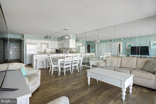 living room featuring a textured ceiling and dark wood-type flooring