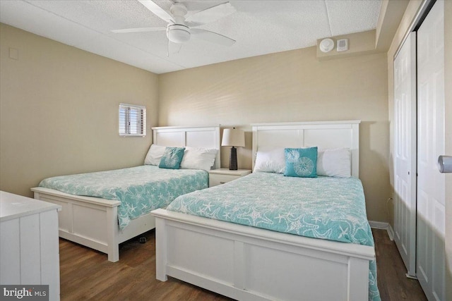 bedroom with a textured ceiling, a closet, ceiling fan, and dark hardwood / wood-style flooring