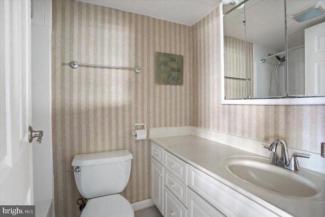 bathroom with vanity, a shower, and toilet