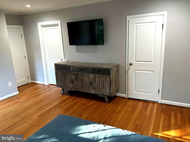 unfurnished living room with ornamental molding and light wood-type flooring