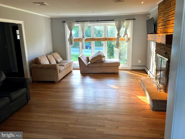 living room with ornamental molding, a fireplace, and light hardwood / wood-style flooring