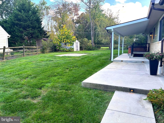 view of yard featuring a storage shed and a patio