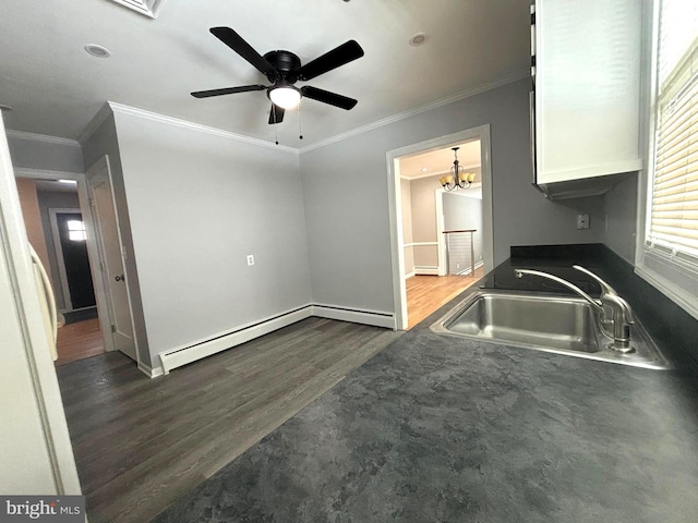 kitchen with sink, white cabinets, dark hardwood / wood-style flooring, ornamental molding, and a baseboard heating unit