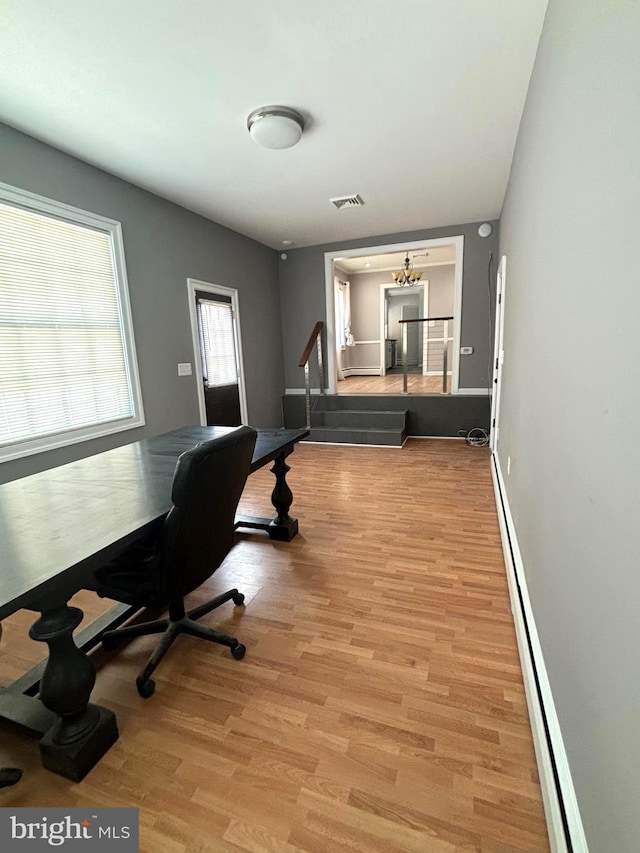 home office with baseboard heating and light wood-type flooring