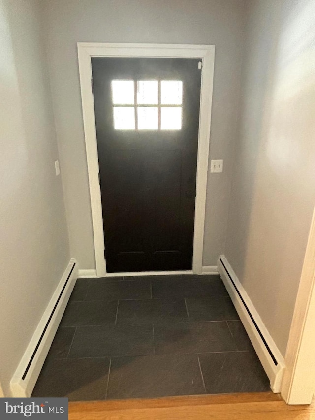 doorway with tile patterned floors and baseboard heating