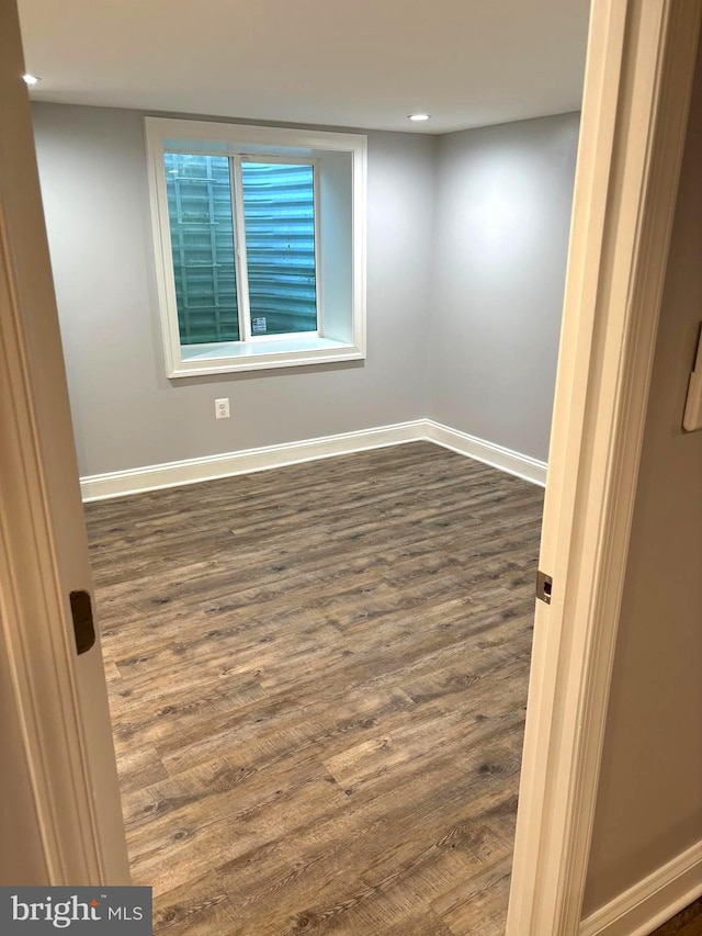 unfurnished room with dark wood-type flooring