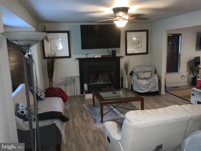 living room featuring wood-type flooring and ceiling fan