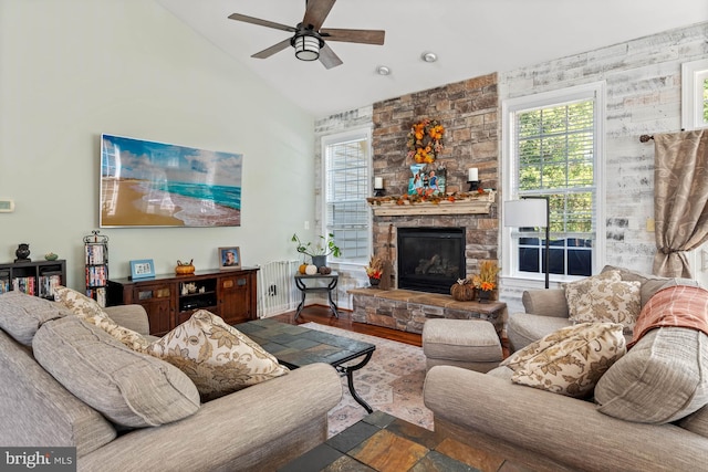 living room featuring ceiling fan, wood-type flooring, a fireplace, and lofted ceiling