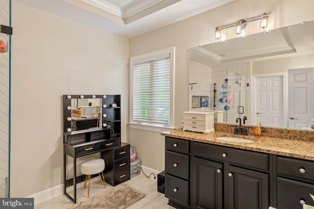 bathroom featuring a shower with door, vanity, and a tray ceiling