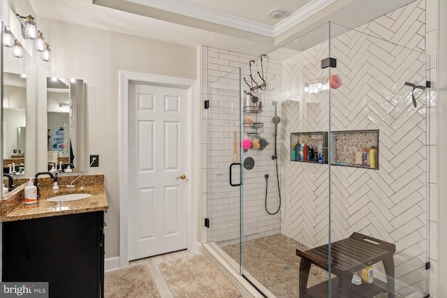 bathroom featuring ornamental molding, tile patterned flooring, a shower with shower door, and vanity