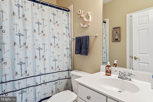 bathroom with walk in shower, vanity, and toilet