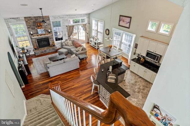 living room with a towering ceiling, plenty of natural light, and a fireplace