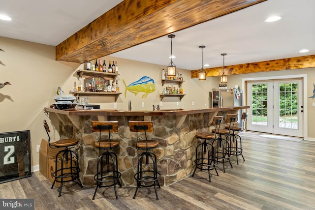 bar with stainless steel fridge with ice dispenser, decorative light fixtures, and dark hardwood / wood-style flooring