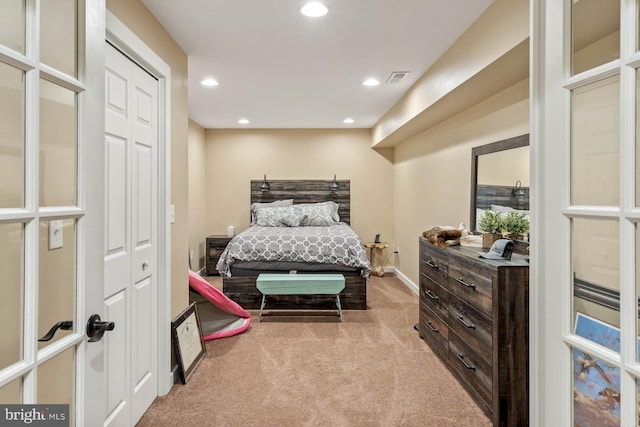 bedroom with light carpet and a closet