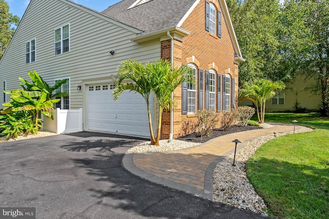 view of side of home with a garage and a yard