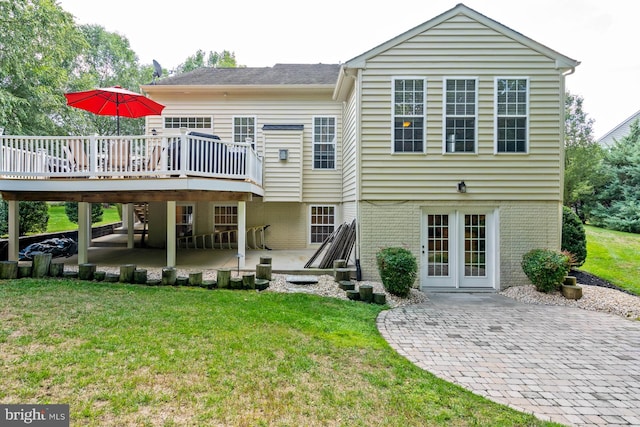 rear view of property with a wooden deck, a yard, and a patio