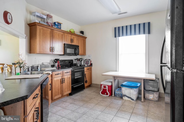 kitchen with light tile patterned flooring and black appliances