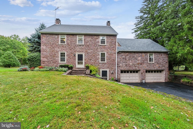 rear view of house with a yard and a garage