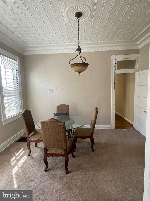 carpeted dining space featuring crown molding