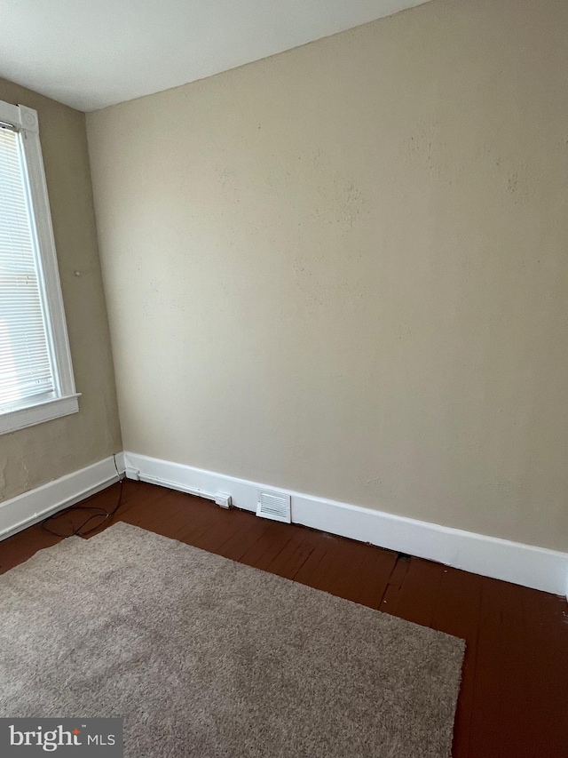 unfurnished room featuring wood-type flooring and a wealth of natural light