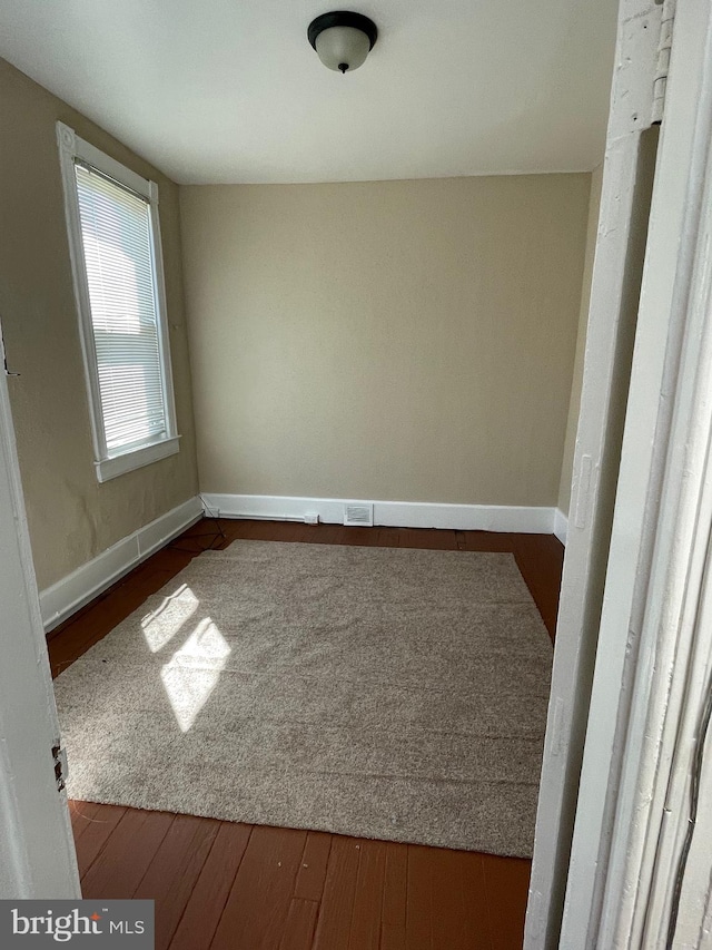 unfurnished room featuring dark wood-type flooring