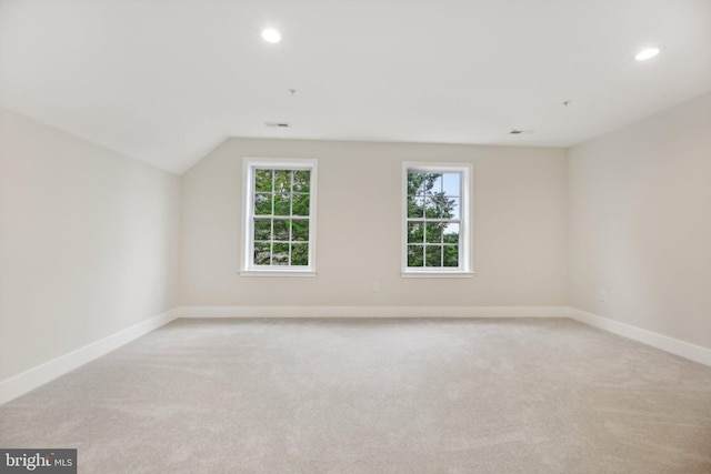 additional living space with lofted ceiling and light carpet