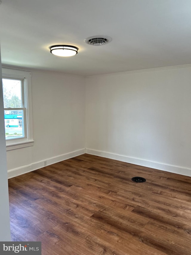 empty room featuring ornamental molding and dark hardwood / wood-style floors