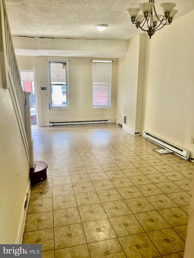 unfurnished room featuring baseboard heating and a textured ceiling