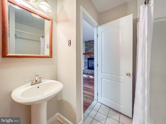 bathroom featuring a stone fireplace and tile patterned floors