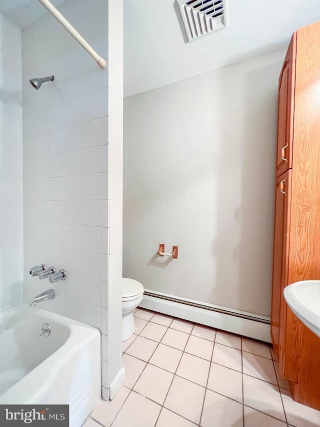 bathroom with a baseboard heating unit, toilet, tiled shower / bath combo, and tile patterned floors