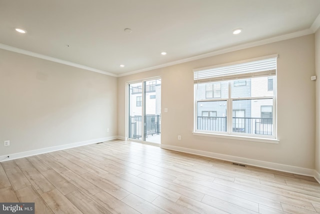 spare room featuring crown molding and light hardwood / wood-style flooring