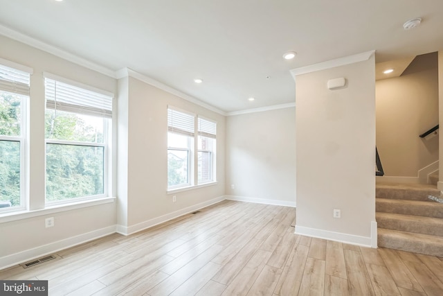 spare room with light wood-type flooring and ornamental molding