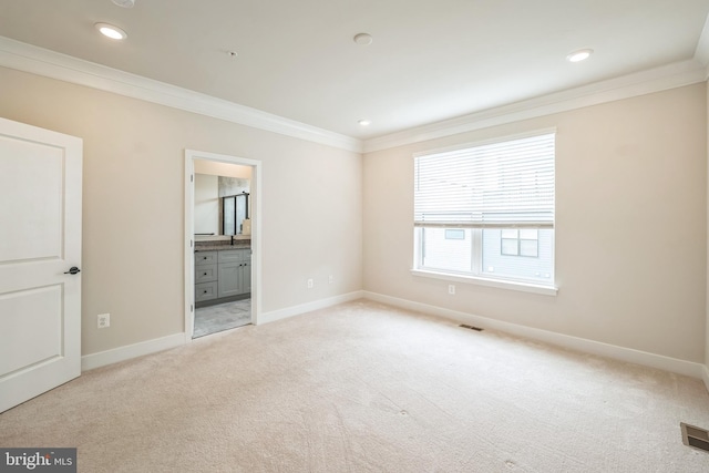 unfurnished bedroom featuring light carpet, connected bathroom, sink, and crown molding