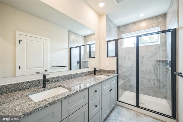 bathroom with vanity and a shower with door