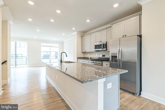 kitchen featuring sink, gray cabinetry, light hardwood / wood-style flooring, appliances with stainless steel finishes, and dark stone counters