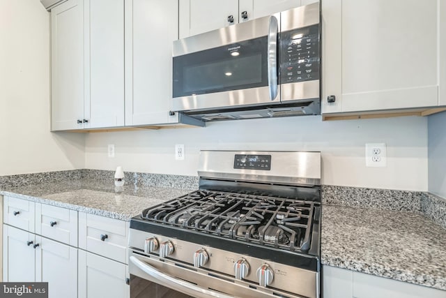 kitchen featuring light stone countertops, white cabinets, and appliances with stainless steel finishes