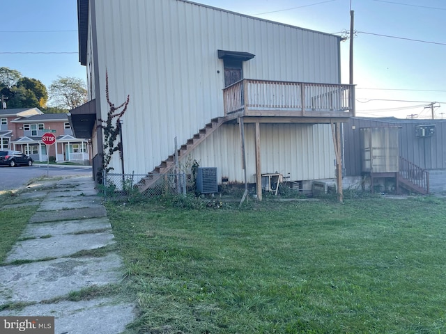 view of side of property with central AC and a yard