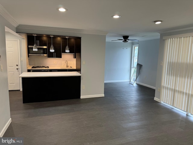 kitchen with hanging light fixtures, a kitchen island, appliances with stainless steel finishes, crown molding, and ceiling fan