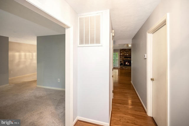 hallway featuring hardwood / wood-style flooring and a textured ceiling