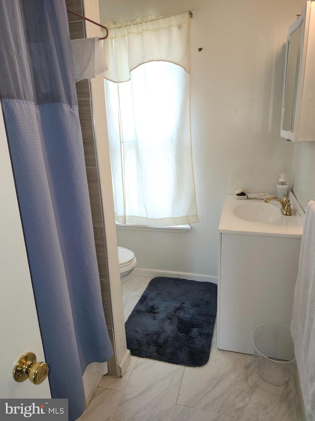 bathroom featuring walk in shower, vanity, and toilet