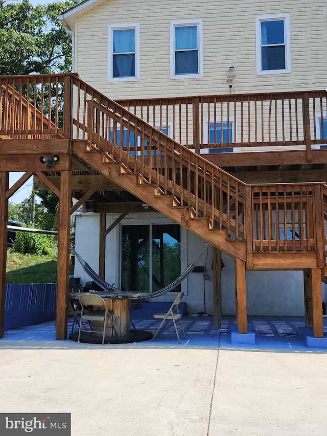 rear view of property with a wooden deck and a patio area