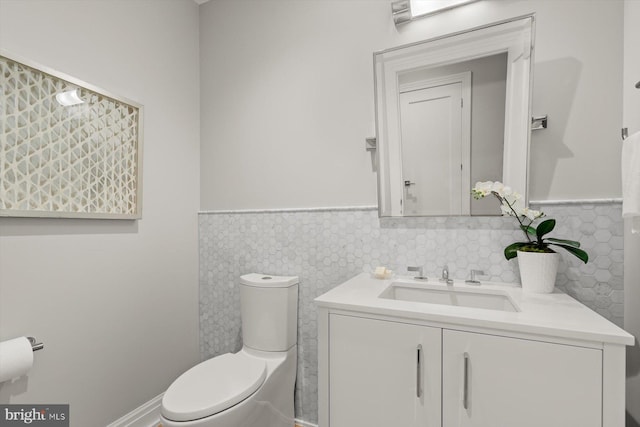 bathroom featuring tile walls, vanity, and toilet