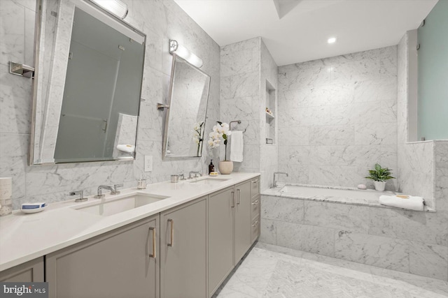 bathroom featuring a bath, tile walls, and vanity