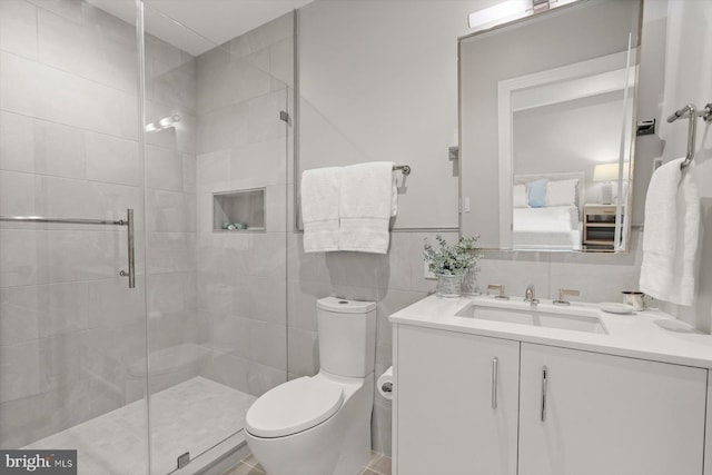 bathroom with walk in shower, tile walls, vanity, and toilet