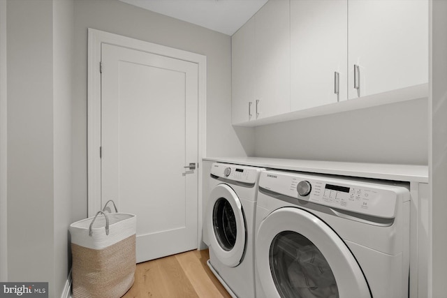 washroom with cabinets, light wood-type flooring, and washer and clothes dryer