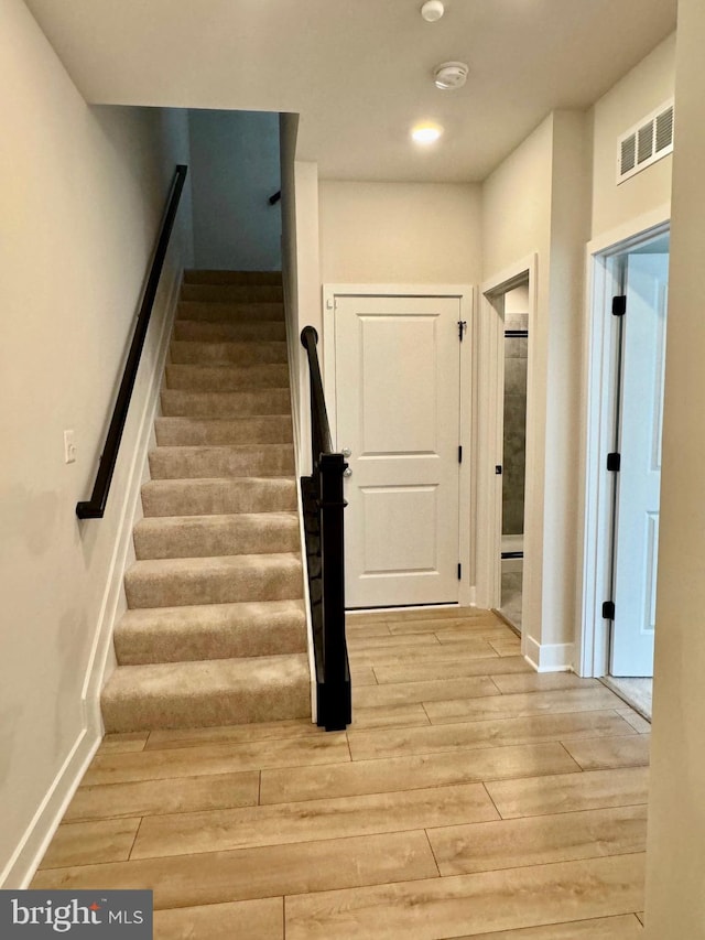 stairs featuring hardwood / wood-style floors