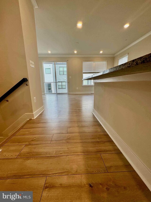 corridor featuring hardwood / wood-style floors and crown molding